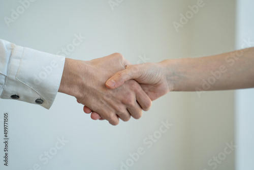 Businessmen shake hands to each other after successful meeting on white background. People come to agreement at work in office room close view