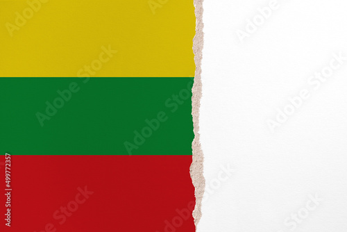 Half- ripped paper background in colors of national flag. Ghana