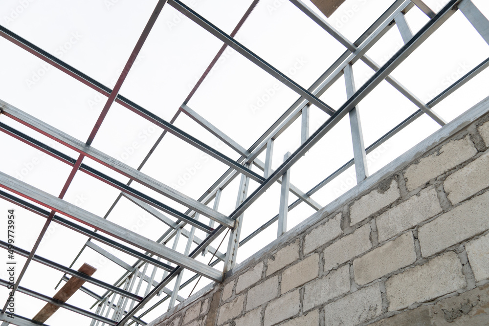 Stucture of steel roof structure on the house under construction. Under the white sky. Stucture of steel roof structure on the house under construction. Under the white sky.