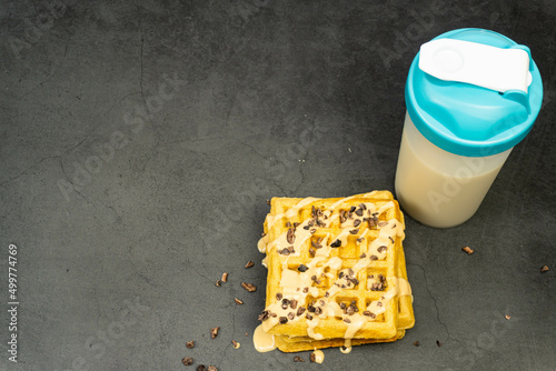 Protein waffle and protein shake from top on dark background