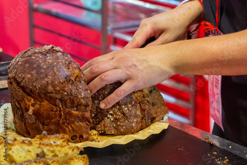 woman's hands cutting a delicious panettone