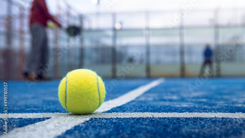 Yellow ball on floor behind paddle net in blue court outdoors. Padel tennis © REC Stock Footage