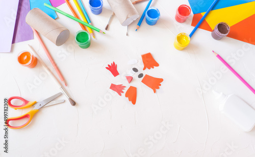 step2. Holiday easy DIY craft idea for kids. Toilet paper roll tube toy chick baby on a white background with colored paper.. Creative Easter decoration eco-friendly, reuse, recycle photo