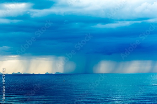 Rain clouds over ocean with rays of light