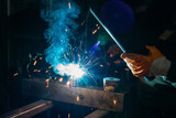 Industrial welder worker welding steel or iron in a factory