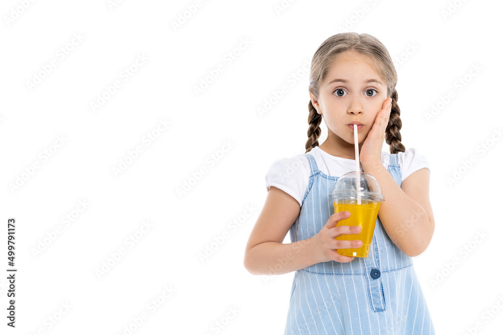 astonished girl touching face while drinking orange juice isolated on white. astonished girl touching face while drinking orange juice isolated on white.