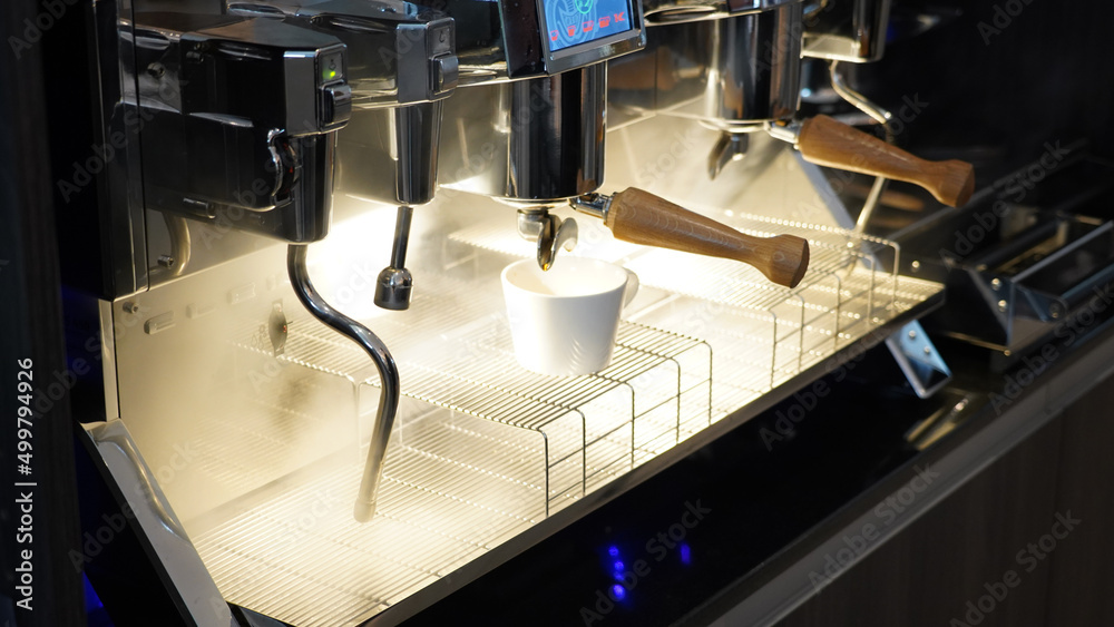 Espresso machine pouring coffee into a mug in a Restaurant in Berlin, Germany.