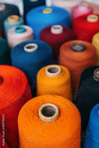 Colorful cotton yarns or threads on spool tube bobbins at cotton yarn factory.