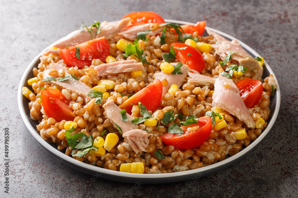 Homemade diet salad made from spelt, tuna, corn, tomatoes and herbs close-up in a plate on the table. horizontal Homemade diet salad made from spelt, tuna, corn, tomatoes and herbs close-up in a plate on the table. horizontal