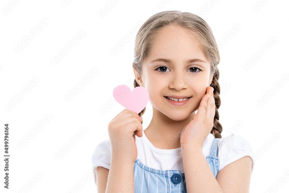 pleased girl touching face while holding pink paper heart isolated on white. pleased girl touching face while holding pink paper heart isolated on white.