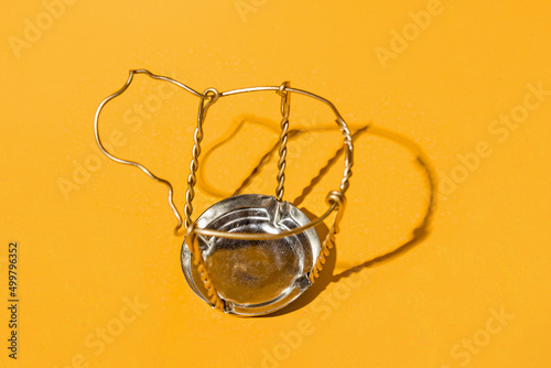 wire muselet for champagne on a yellow background close-up photo