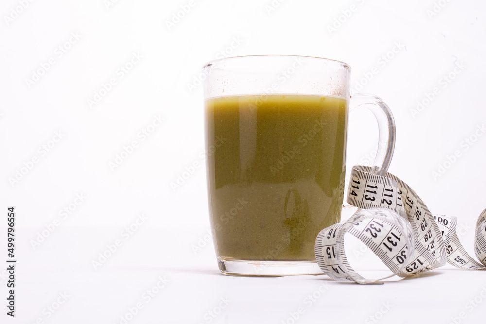 a glass with a green drink and a tape centimeter for weight loss a glass with a green drink and a tape centimeter for weight loss