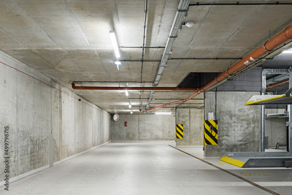 Garaż podziemny z miejscami parkingowymi. Ściany garażu wykonane z betonu. Parking na platformie. Oszczędność miejsc parkingowych - obrazy, fototapety, plakaty 