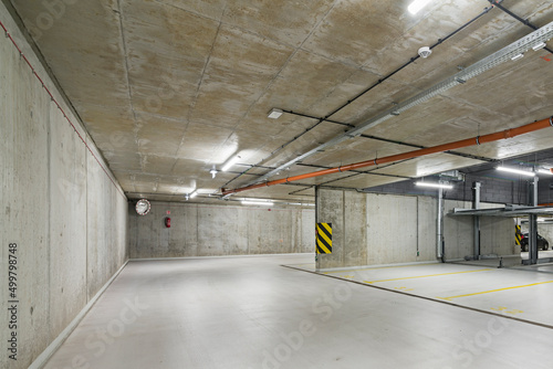 Garaż podziemny z miejscami parkingowymi. Ściany garażu wykonane z betonu. Parking na platformie. Oszczędność miejsc parkingowych