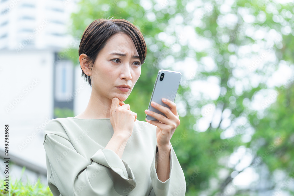 スマホを使うミドル女性(新緑・屋外) スマホを使うミドル女性(新緑・屋外)