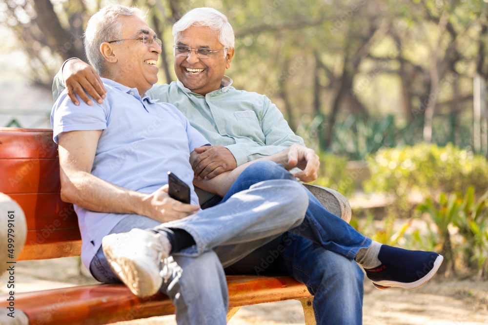 Two happy senior male friends spending leisure time at park Two happy senior male friends spending leisure time at park