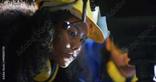 UntitleIndustrial engineer, technician worker wearing uniform, safety hard hat using tablet computer checking control automated robotic arm machine in factory. Automatic manufacturing