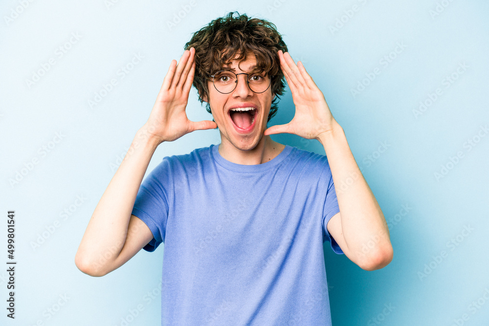 Young caucasian man isolated on blue background receiving a pleasant surprise, excited and raising hands. Young caucasian man isolated on blue background receiving a pleasant surprise, excited and raising hands.