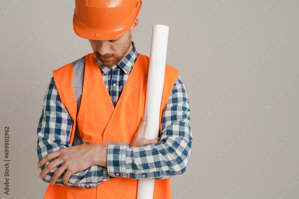 White man worker wearing helmet and vest posing with drawing White man worker wearing helmet and vest posing with drawing