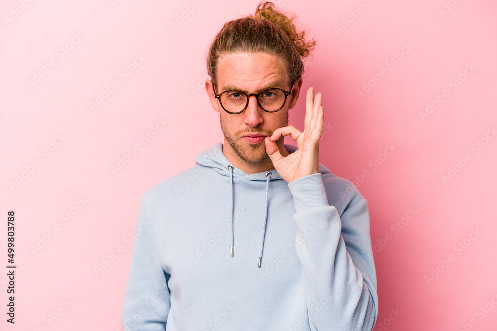 Young caucasian man isolated on pink background with fingers on lips keeping a secret.