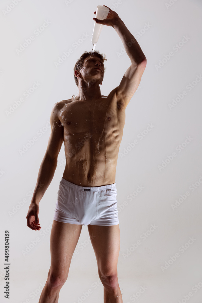 Fototapeta premium Modern, contemp. Young artistic man, flexible male dancer dancing isolated on grey studio background. Art, motion, flexibility, inspiration concept.