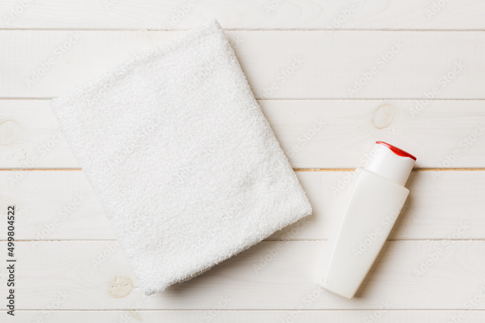 Obraz premium Cosmetic shampoo bottle mockup with towels on a colored table. Bathroom background, toilet accessories for hand and body care