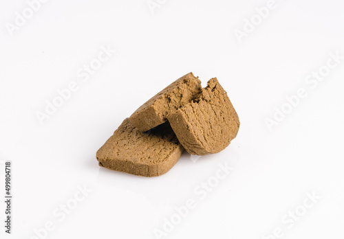 Two marijuana cannabis pollen hashish on a white background. photo