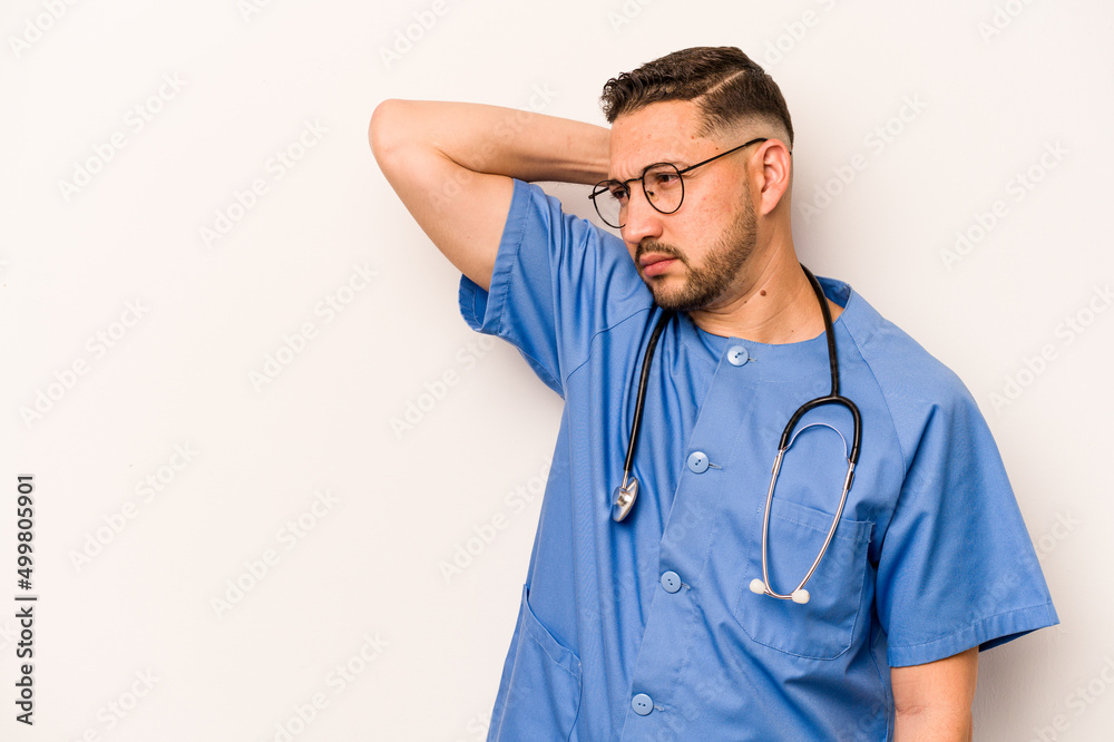 Hispanic nurse man isolated on white background touching back of head, thinking and making a choice. Hispanic nurse man isolated on white background touching back of head, thinking and making a choice.