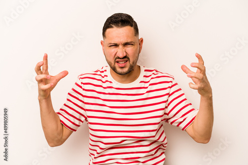 Young hispanic man isolated on white background screaming with rage.