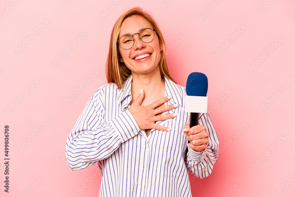 Young caucasian TV presenter woman isolated on pink background laughs out loudly keeping hand on chest. Young caucasian TV presenter woman isolated on pink background laughs out loudly keeping hand on chest.