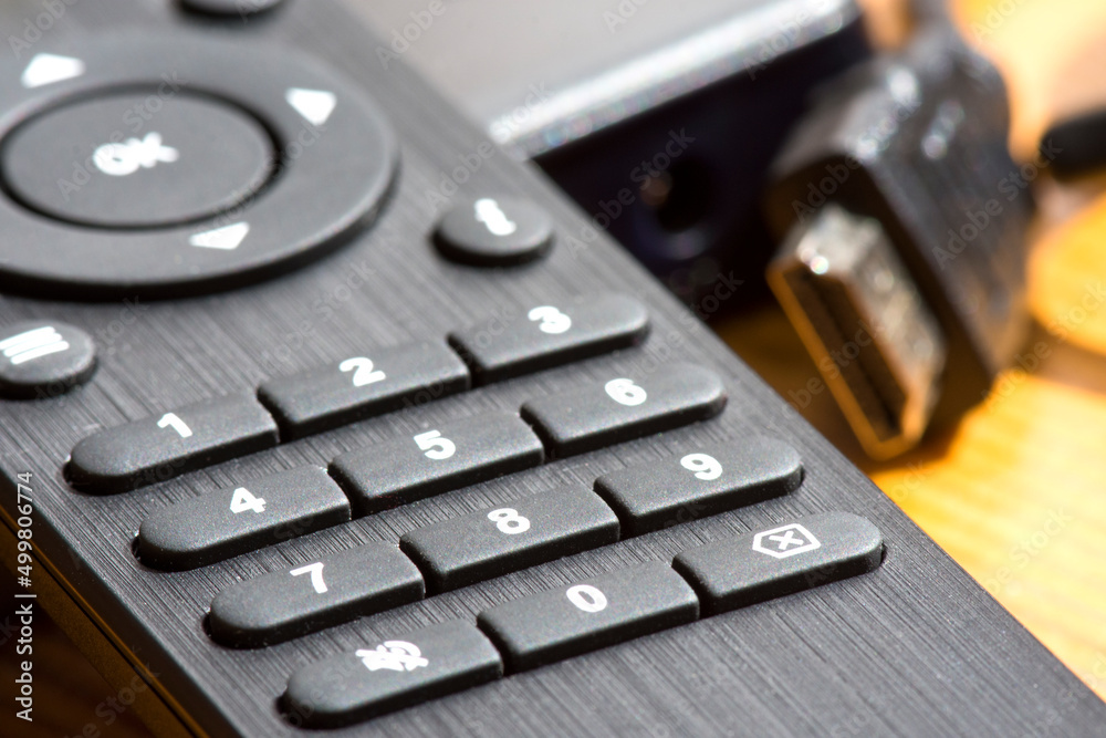 Black TV remote control close up. Number buttons on the remote control. Сhanging and setting channels. Black TV remote control close up. Number buttons on the remote control. Сhanging and setting channels.
