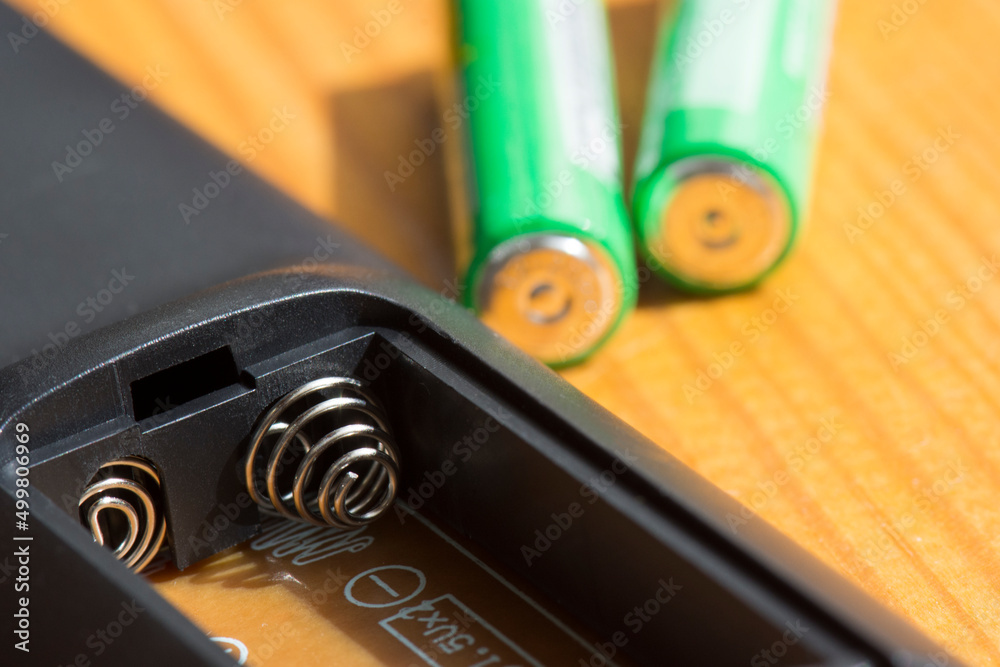 AA batteries and TV remote control. Replacing the batteries in the