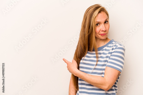 Young caucasian woman isolated on white background smiling and pointing aside, showing something at blank space.