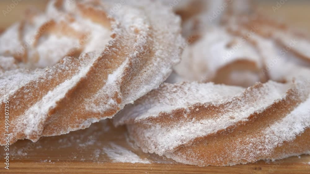 Close up of fresh baked cookies is sprinkled powdered sugar. Shortbread dough, shortcake baking. Close up of fresh baked cookies is sprinkled powdered sugar. Shortbread dough, shortcake baking.