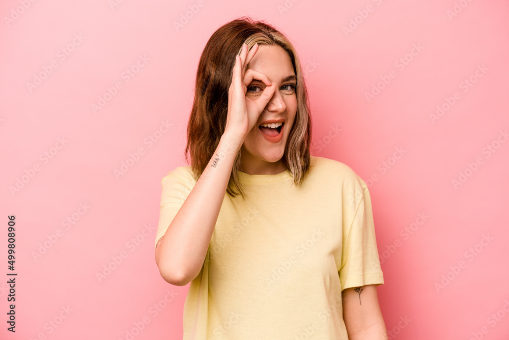 Young caucasian woman isolated on pink background excited keeping ok gesture on eye. Young caucasian woman isolated on pink background excited keeping ok gesture on eye.