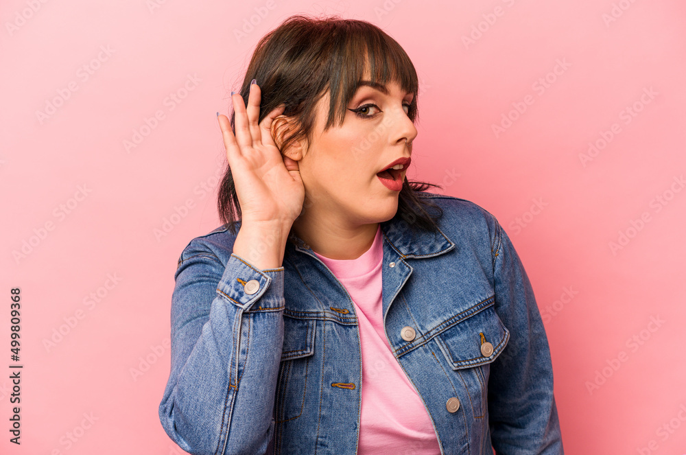 Young caucasian woman isolated on pink background trying to listening a gossip. Young caucasian woman isolated on pink background trying to listening a gossip.