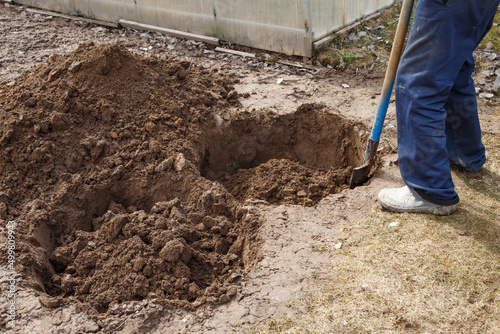 man digging a hole for planting a fruit tree in the garden