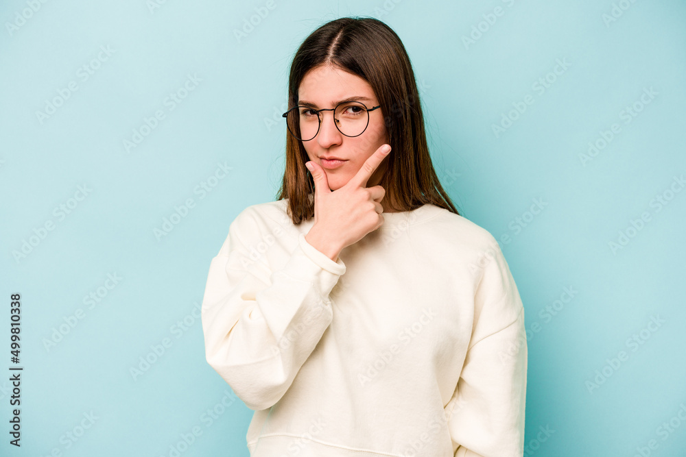 Young caucasian woman isolated on blue background contemplating, planning a strategy, thinking about the way of a business. Young caucasian woman isolated on blue background contemplating, planning a strategy, thinking about the way of a business.