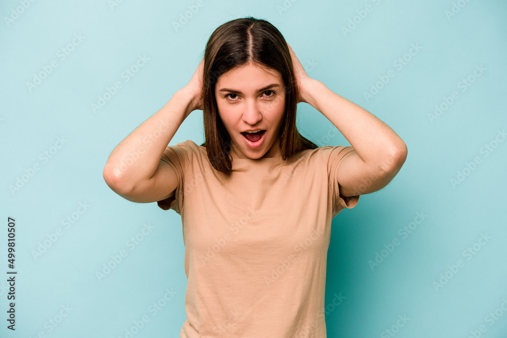 Young caucasian woman isolated on blue background screaming, very excited, passionate, satisfied with something. Young caucasian woman isolated on blue background screaming, very excited, passionate, satisfied with something.
