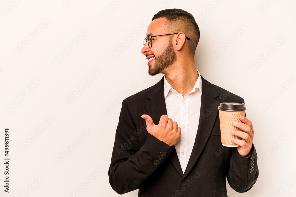 Young business hispanic man holding takeaway coffee isolated on white background points with thumb finger away, laughing and carefree. Young business hispanic man holding takeaway coffee isolated on white background points with thumb finger away, laughing and carefree.