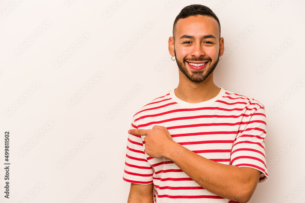 Young hispanic man isolated on white background smiling and pointing aside, showing something at blank space. Young hispanic man isolated on white background smiling and pointing aside, showing something at blank space.