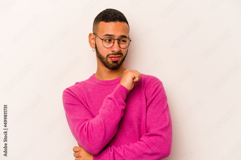 Obraz premium Young hispanic man isolated on white background confused, feels doubtful and unsure.