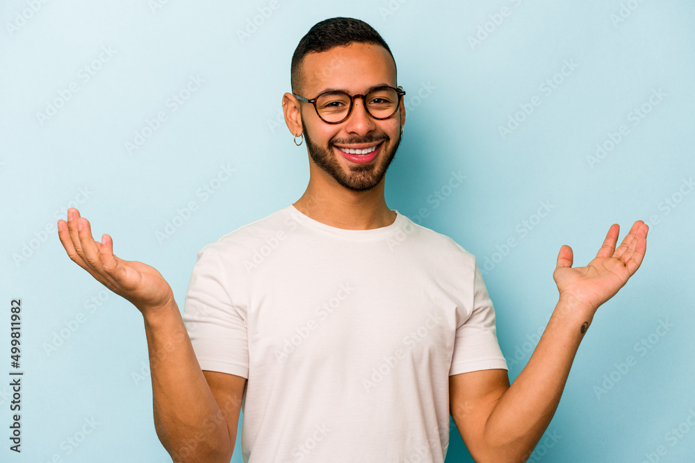 Young hispanic man isolated on blue background joyful laughing a lot. Happiness concept. Young hispanic man isolated on blue background joyful laughing a lot. Happiness concept.