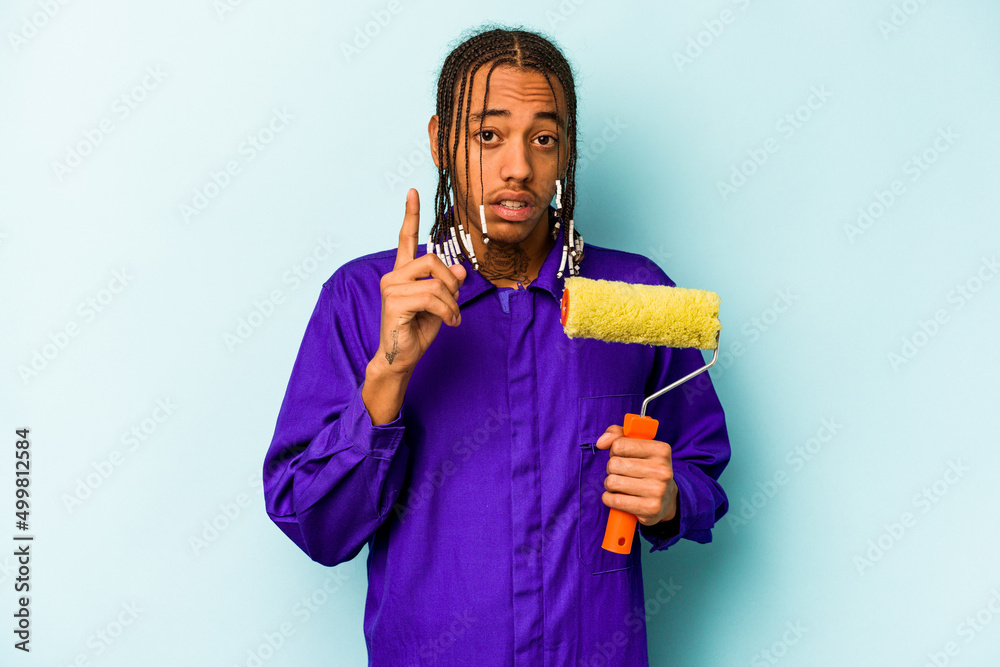 Young African American painter man isolated on blue background having an idea, inspiration concept. Young African American painter man isolated on blue background having an idea, inspiration concept.