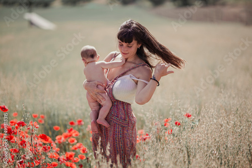 Mother and baby in her arms in the field