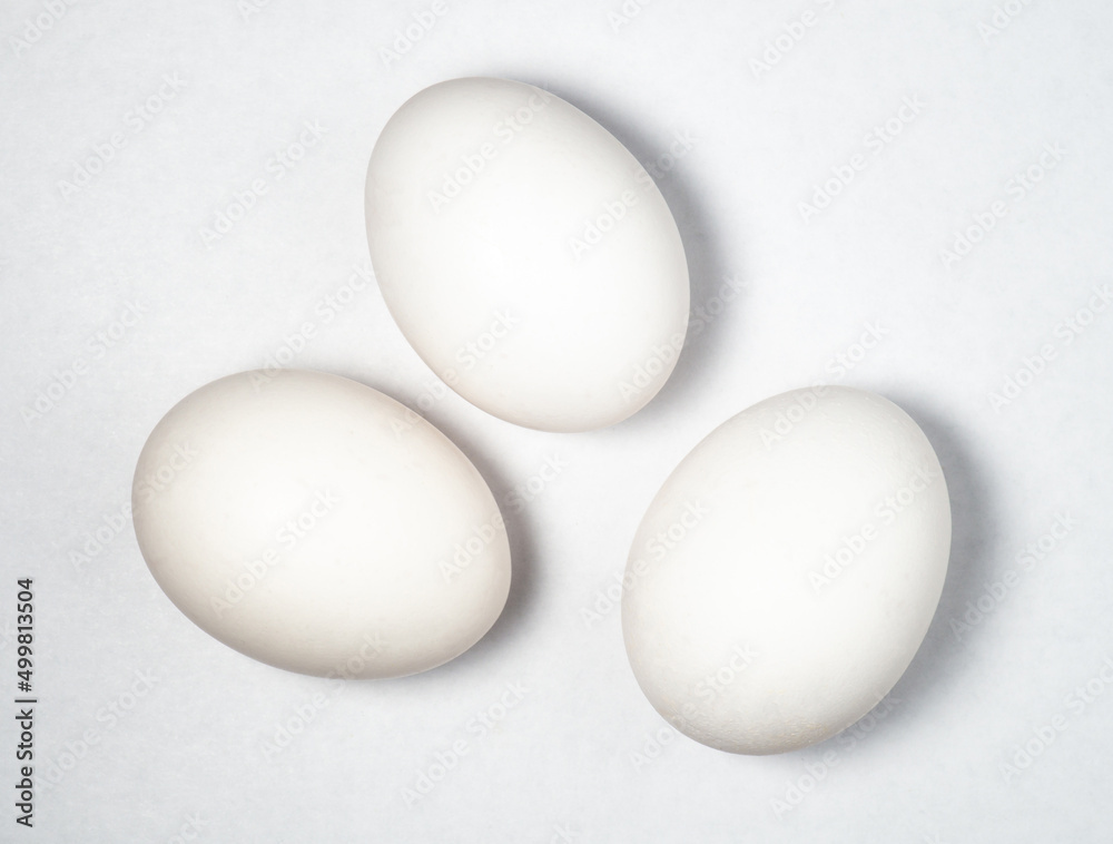 Three eggs on a white background. Cooking. Breakfast preparation. Healthy diet. Three eggs on a white background. Cooking. Breakfast preparation. Healthy diet.