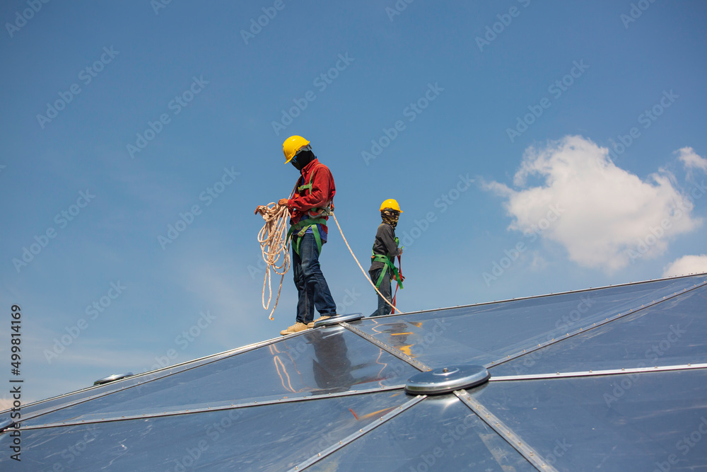 Male two workers rope access height safety connecting with eight knots safety harness, clipping into roof dome construction site oil tank. Male two workers rope access height safety connecting with eight knots safety harness, clipping into roof dome construction site oil tank.