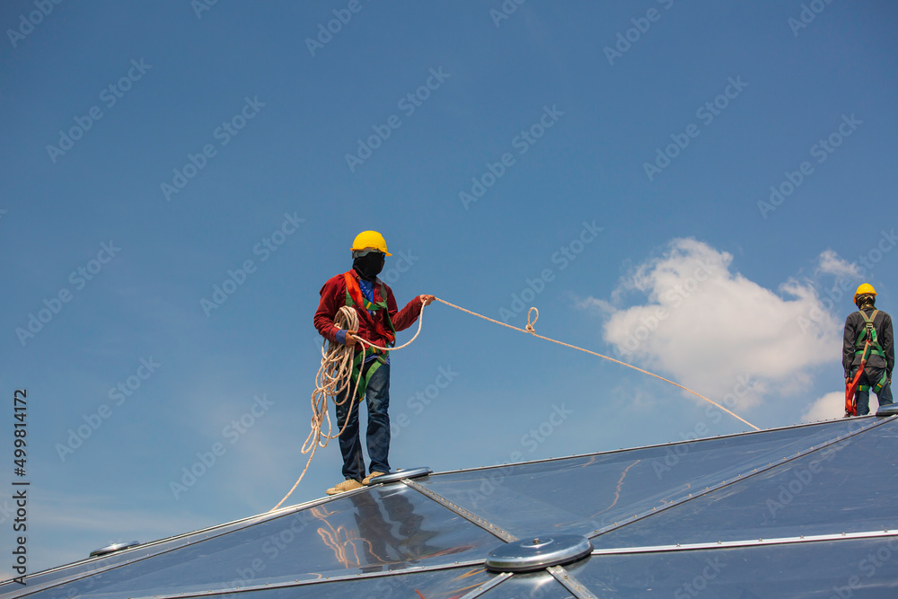 Male two workers rope access height safety connecting with eight knots safety harness, clipping into roof dome construction site oil tank. Male two workers rope access height safety connecting with eight knots safety harness, clipping into roof dome construction site oil tank.