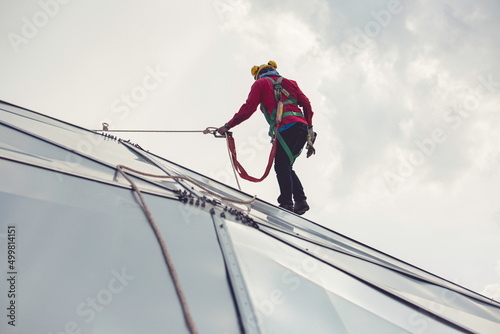 Fotografie Male workers rope access height safety connecting with eight knots safety harness construction site oil tank dome