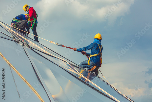 Slika na platnu Male workers rope access height safety connecting with a knot safety harness, cl